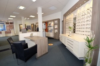 Modernes Optiker-Geschäft mit Brillenauswahl, Beratungstresen und stilvoller Einrichtung.